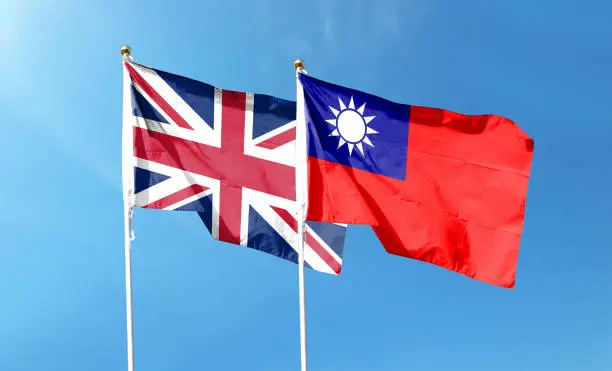 British flag and Taiwan flag on cloudy sky. waving in the sky