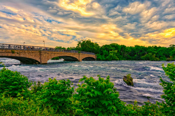 istock Bridge across river over color morning sky background 1413026874