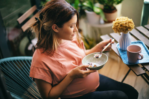 Pregnant woman enjoying a healthy breakfast. stock photo