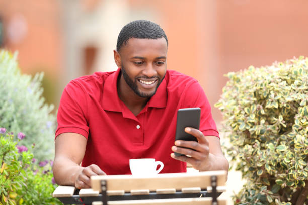 istock Happy man in red using smart phone in a coffee shop 1413031816