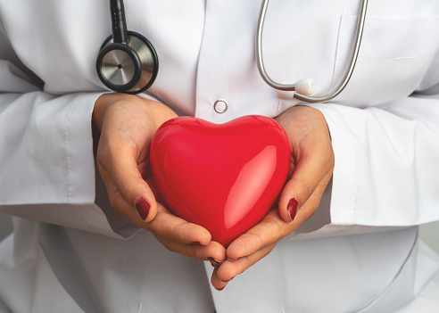 Médico médico sosteniendo la forma del corazón rojo en la mano, concepto médico stock foto photo