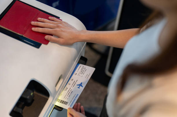 female hand holding personal passport scanning at the self service checkin counter for get boarding pass at the airport terminal. - airport airport check in counter ticket ticket machine imagens e fotografias de stock