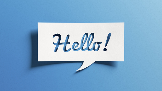 Hello salutation or greeting word to welcome someone or initiate a conversation. Design with letters cut out in paper speech bubble over blue background. Communication concept, introduction.