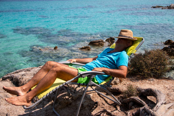 Portrait of a handsome man lying on a deckchair and resting.