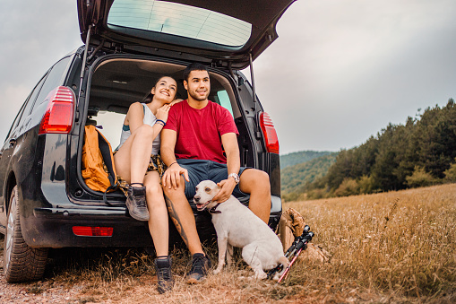 Couple enjoy with dog in nature and resting after hiking