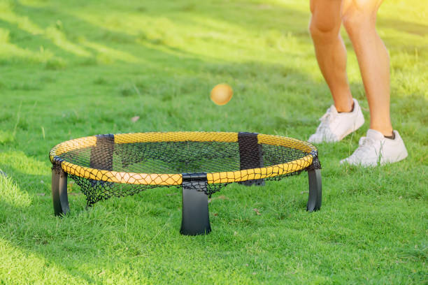 Playing ball with mini beach volleyball net on a green grass lawn. Modern Leisure sports and fun recreation with friends stock photo