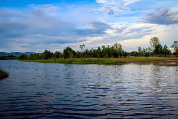 istock Flowing River in steppe with reflection of blue sky on surface 1413040825