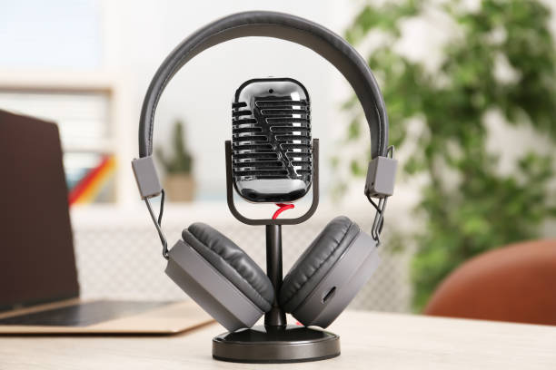 istock Microphone, modern headphones and laptop on table indoors 1413041488