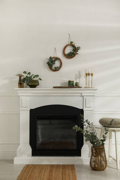 istock Stylish room with beautiful fireplace and eucalyptus branches 1413041496