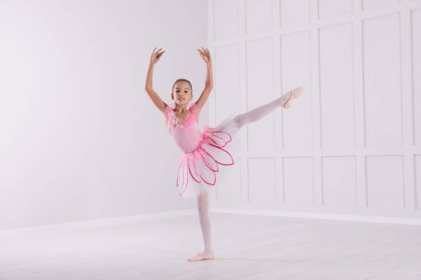 istock Beautifully dressed little ballerina dancing in studio 1413041798