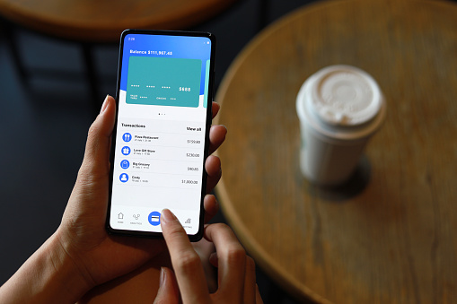 Cropped image of woman checking bank account and spending using her mobile device. Convenience and easy banking with technology.