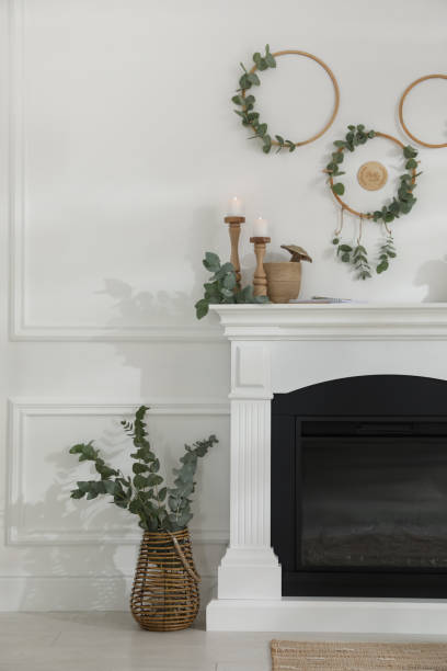 istock Stylish room with beautiful fireplace and eucalyptus branches 1413041878