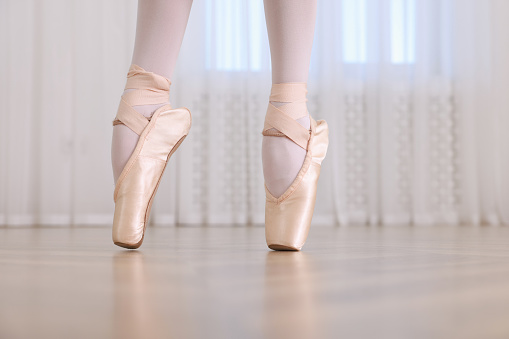 Ballet, woman and legs on tiptoes dancing in studio for art, music class and floor mockup. Closeup female ballerina, dancer and pointe feet position for performance, balance shoes or concert training