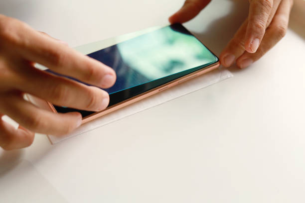 Man cleaning the phone display before applying scratch resistant protective glass
