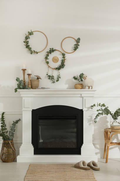 istock Stylish room with beautiful fireplace and eucalyptus branches 1413042027