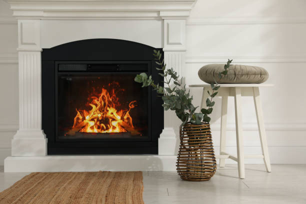 istock Beautiful eucalyptus branches in vase and stool near fireplace indoors 1413042079