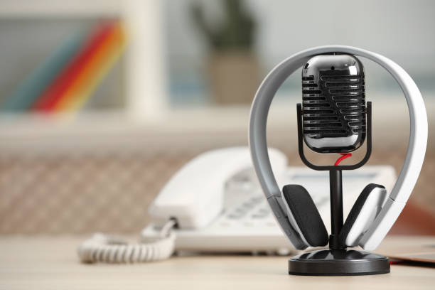 istock Microphone, modern headphones and desktop telephone on table indoors, space for text 1413042164