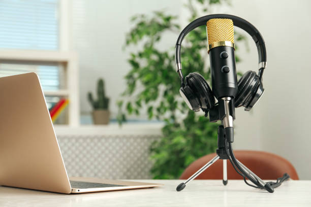 istock Microphone, modern headphones and laptop on table indoors 1413042256