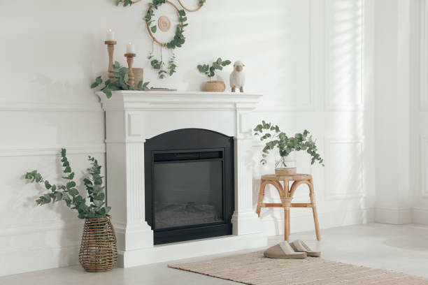 istock Stylish room with beautiful fireplace and eucalyptus branches 1413042807