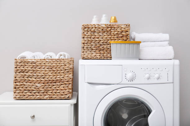 istock Laundry room with washing machine, detergents and clean towels. Tidying up method 1413043304