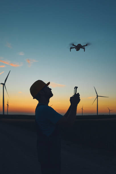 engineer mechanic using drone for inspection in a windmill farm park. - stockyards industrial park imagens e fotografias de stock