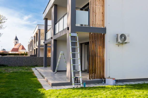 Paint equipment and ladders outside modern house against sky during sunny day