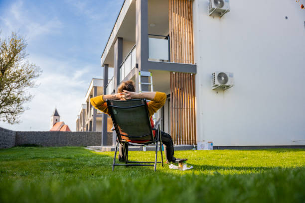 Tired man resting on deck chair in yard while taking break from coloring