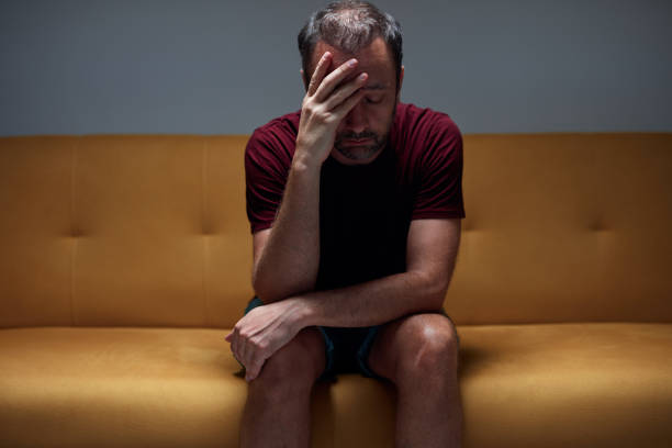 istock Man with headache pain, anxiety, depression, sadness at home. 1413047052