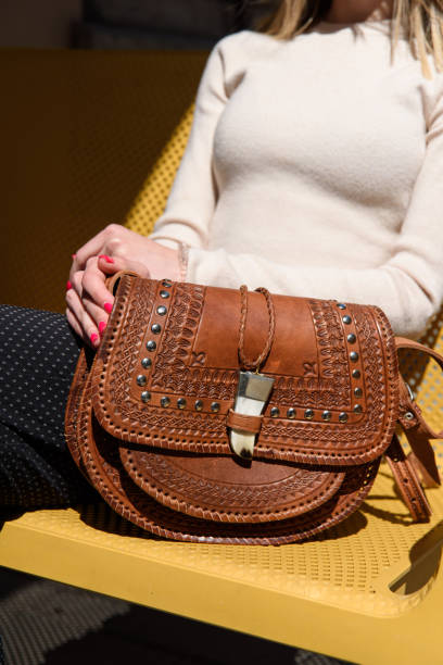 istock small brown women's leather bag with a carved pattern. selective focus 1413047224
