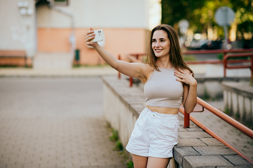 teenager girl taking selfie in the street