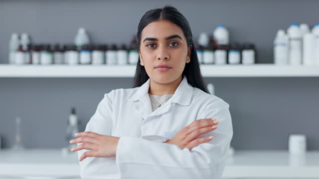 Proud medical biologist, scientist or chemist as a frontline worker in clinical biology or medicine at an innovative research lab. Face of confident expert female pharmacist with folded arms