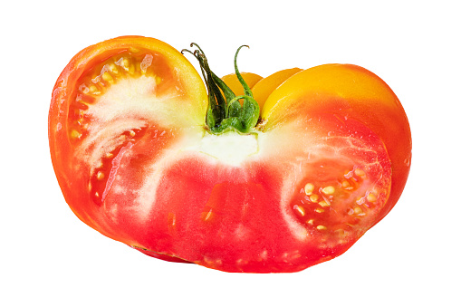 Cutted in half delicious and juicy fresh tomato isolated on a white background with paths. Organic products are not of perfect shape and color