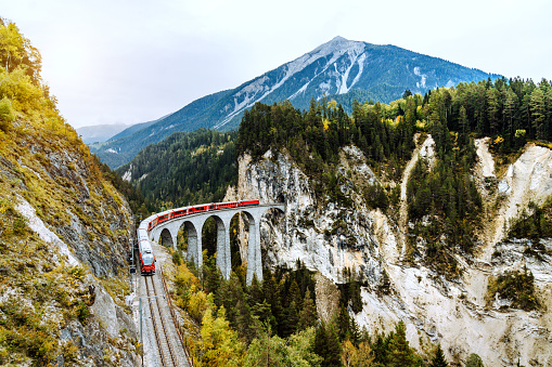 Train crossing Landwasser Viaduct on raethian railway in Filisur – Albula, Graubunden, Switzerland \nThe Landwasser Viaduct is a single track limestone railway viaduct near Filisur in the canton of Graubünden, Switzerland.