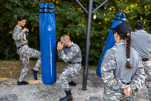 Caucasian female and male military team, having an outdoor military training, leaded by female sergeant