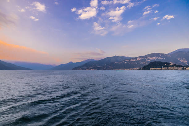 vue sur le magnifique lac contre les montagnes et le ciel au coucher du soleil - como mountain horizon landscape photos et images de collection