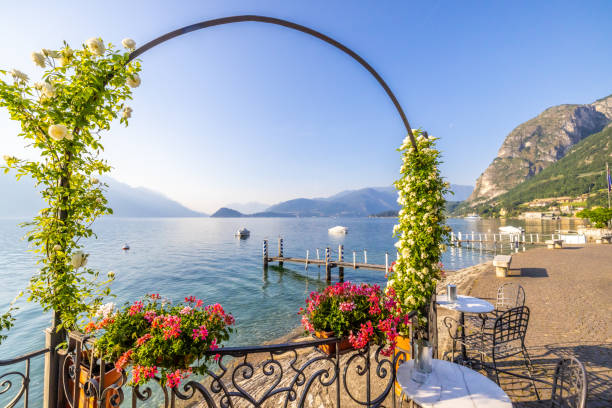 arco coperto di creeper in un ristorante in stile classico contro il lago nella città vecchia. lenno, lago di como, italia - lenno foto e immagini stock