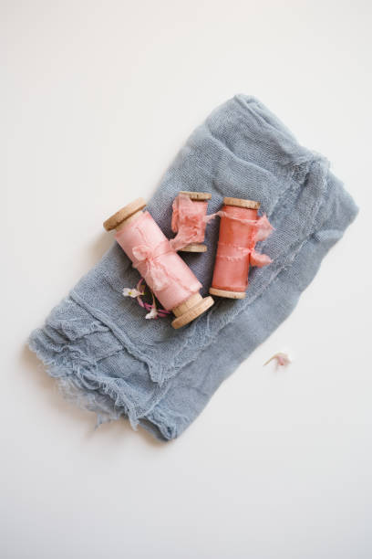 istock Fabric decoration composition. Gray gauze, pink silk ribbons lie on the table 1413052908