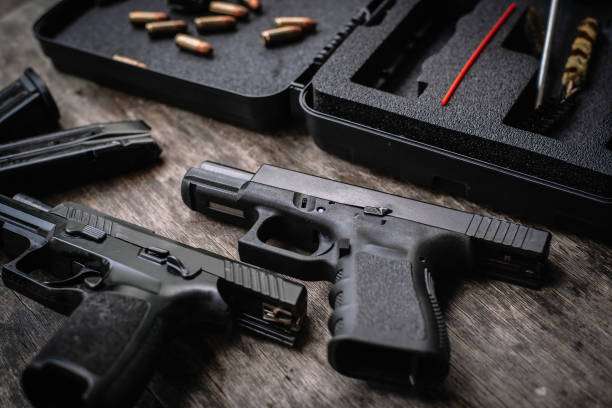 istock Disassembly and cleaning Maintaining a 9mm semi-automatic pistol on a wooden table. 1413053019