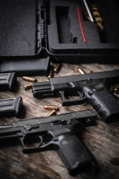 istock Disassembly and cleaning Maintaining a 9mm semi-automatic pistol on a wooden table. 1413053023