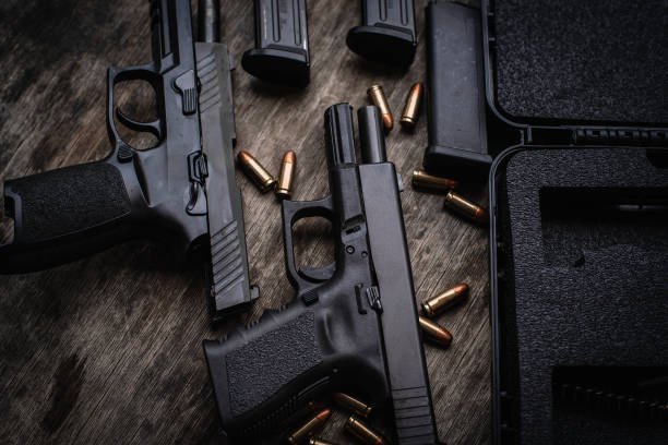 два 9-мм пистолета держат затворы на деревянном столе. - target shooting стоковые фото и изображения