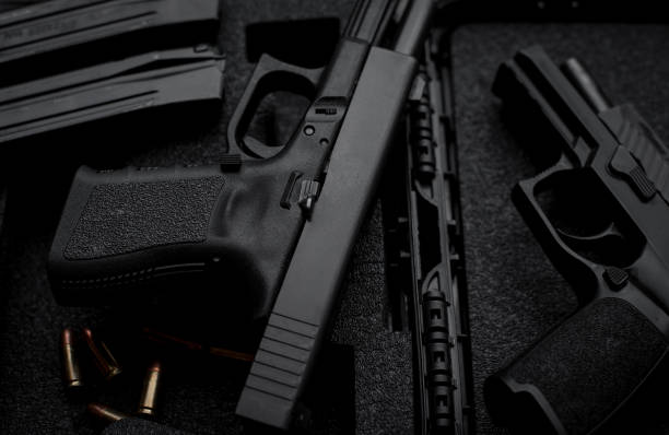 istock Two 9mm pistols hold slides on a wooden table. 1413053052