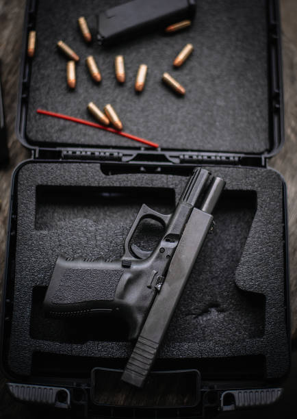 istock Disassembly and cleaning Maintaining a 9mm semi-automatic pistol on a wooden table. 1413053173