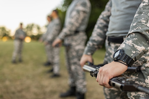 Caucasian female and male military team, having an outdoor ground military training, leaded by female sargeant