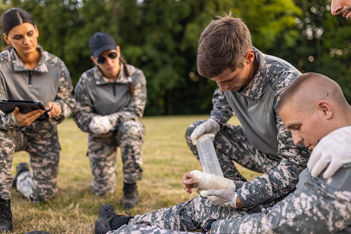 Military team having an first aid training course
