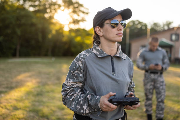Woman from the military team, driving the drone while using drone remote control