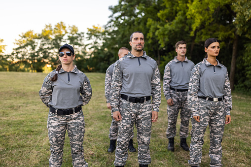 Group of Caucasian female and male people, having an outdoor military training