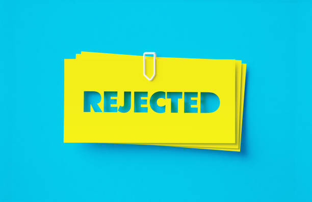 Rejected written cut out yellow adhesive notes sitting on blue background. Horizontal composition with copy space.