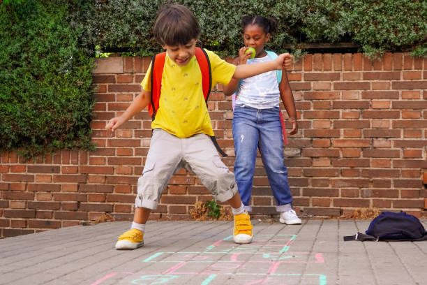 multiethnic kids playing hopscotch on school playground. multiethnic kids playing hopscotch on school playground. back to school concept. multiethnic children group food elementary student healthy eating schoolboy stock pictures, royalty-free photos & images