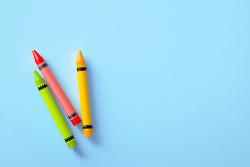 Colorful crayons on blue background. Horizontal composition with copy space.