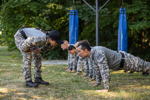 Equipo militar con un entrenamiento militar al aire libre, dirigido por la sargento photo